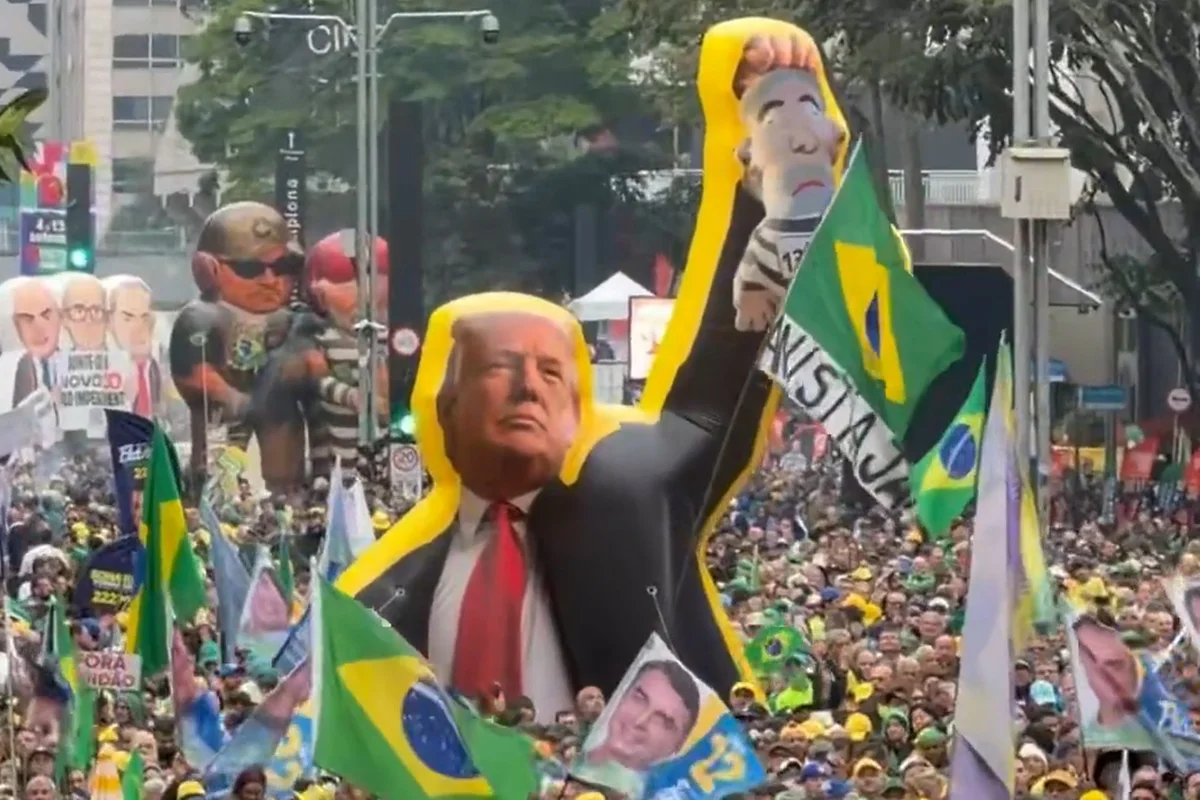 Boneco inflável de Donald Trump segurando caricatura de Lula no ato da Avenida Paulista